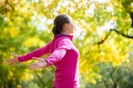 portrait of a woman outdoors in a sportswear hands outstreched