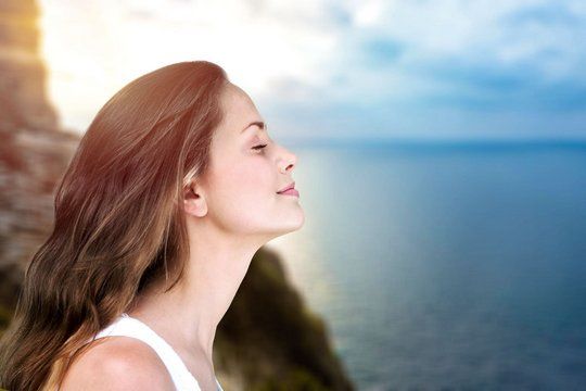 young beautiful woman breathing outdoor with blurred background