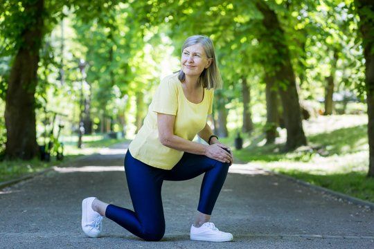 senior active woman on a jog injured her leg and knee grayhaired pensioner in a summer park