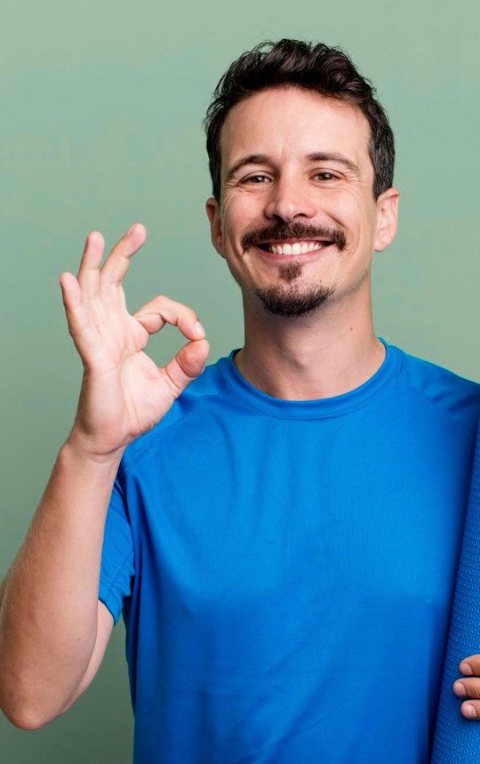mann mit sport matte und gluecklichem gesicht zeigt seine gutheissung